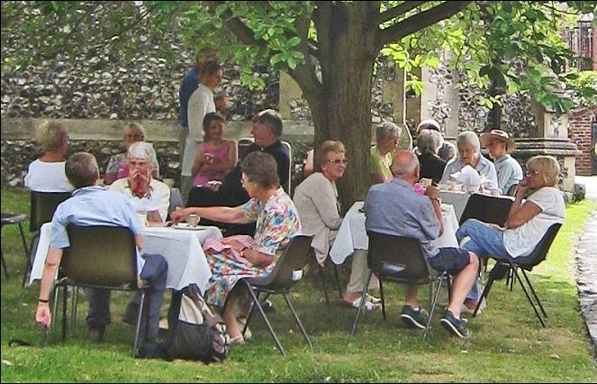 Parishioners enjoying cream teas in a shady spot in the lower churchyard