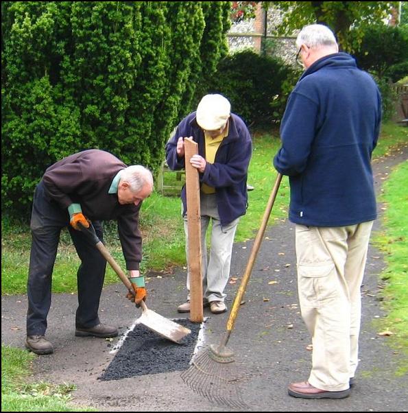 Danger: Men at Work! Peter Jones and Ian Forster repair a pothole whilst being closely supervised by Michael Forsdike